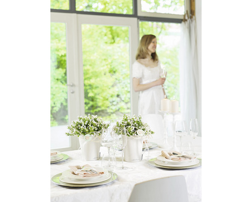 Festligt dukat bord med blomsterarrangemang och ljus för ett speciellt tillfälle.