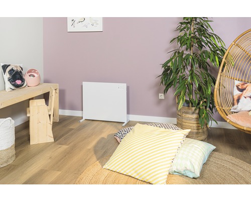 Vardagsrum med vit värmare, krukväxt och sittplatser