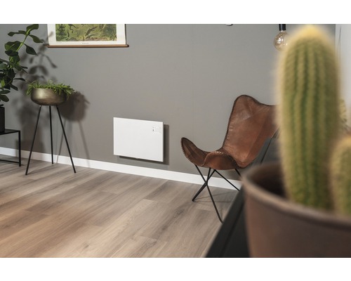 Vardagsrum med elvärme på väggen och läderfåtölj