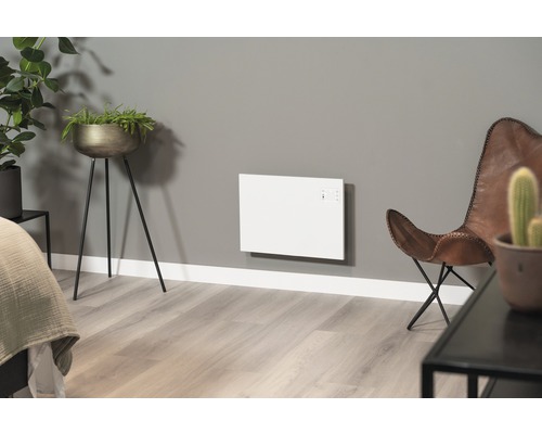 Vardagsrum med väggvärme, blomkrukor och läderfåtölj.