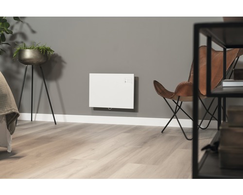 Vardagsrum med väggmonterad värme, fåtölj och växt