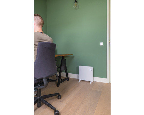 Kontor med skrivbord, kontorsstol och vit värmare