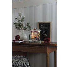 Dekorativt julstilleben med upplyst snöglob på ett träbord