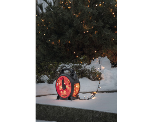 Ljusslinga på kabelvinda framför snötäckt buske