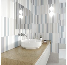 Modernt badrum med tvättställ, spegel och randiga plattor