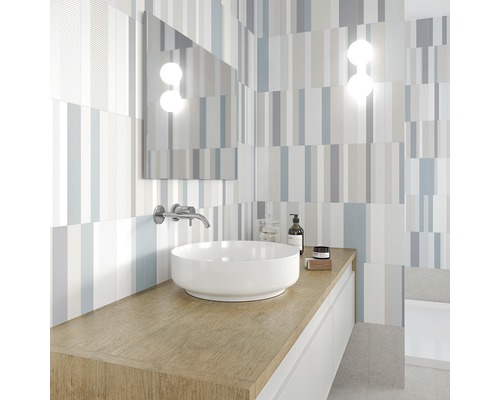 Modernt badrum med tvättställ, spegel och randiga plattor