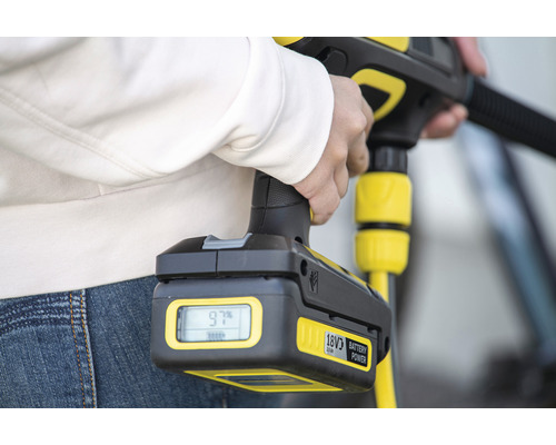 En person håller en högtryckstvätt med ett 18 volts batteri