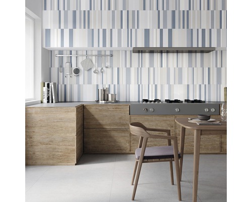 Köksscen med kaklat stänkskydd i randigt mönster, köksmöbler med träutseende och matbord med stol