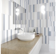 Modernt badrum med handfat, spegel och randigt kakel