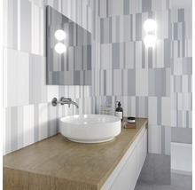 Modernt badrum med tvättställ, spegel och väggplattor med randigt mönster