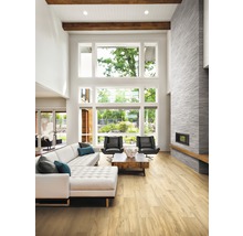 Ljust vardagsrum med soffa, fåtöljer, öppen spis och stort fönster