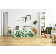 Ljust sovrum med trägolv, säng, fåtölj och dekoration