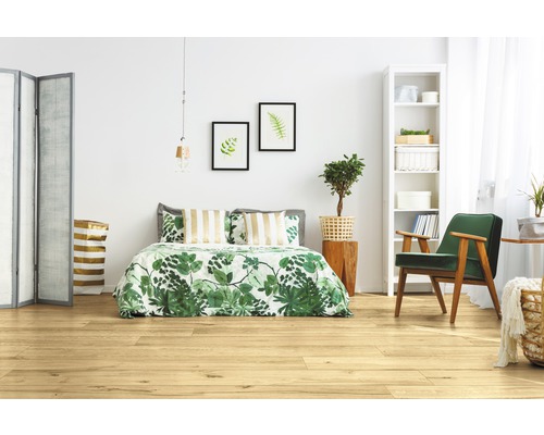 Ljust sovrum med trägolv, säng, fåtölj och dekoration