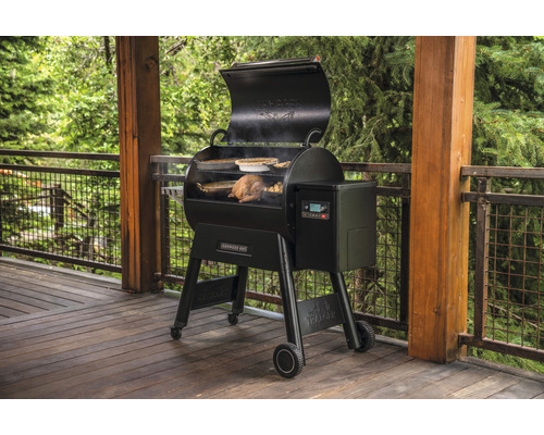 Traeger pelletgrill med mat på en träterrass