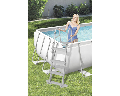 Scen med stålramspool och en kvinna som går ner i vattnet via en poolstege