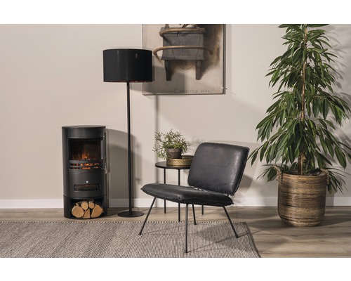 Vardagsrum med elektrisk eldstad, golvlampa, fåtölj, sidobord, krukväxt och matta