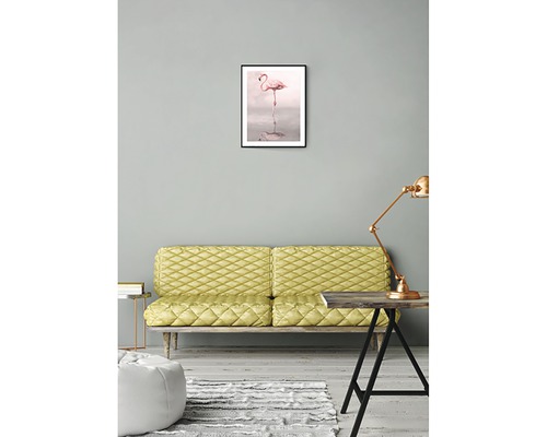 Vardagsrum med soffa, bord, lampa och inramad flamingobild