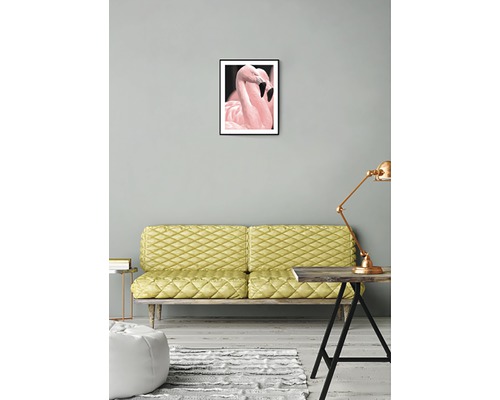 Inramad bild med två flamingor på väggen ovanför en soffa