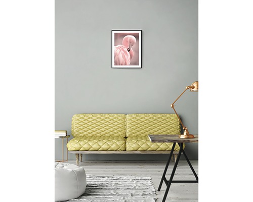 Vardagsrum med soffa, bordslampa och inramad flamingobild på väggen