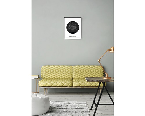 Vardagsrum med soffa, bordslampa och inramad stjärnbildsposter