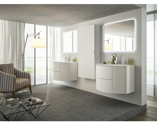 Badrum med handfat, speglar, skåp och fåtölj i ett ljust rum