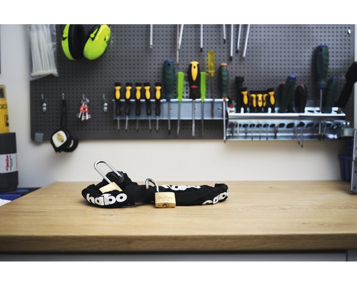 Svart textillås med två hänglås i mässing på träbord