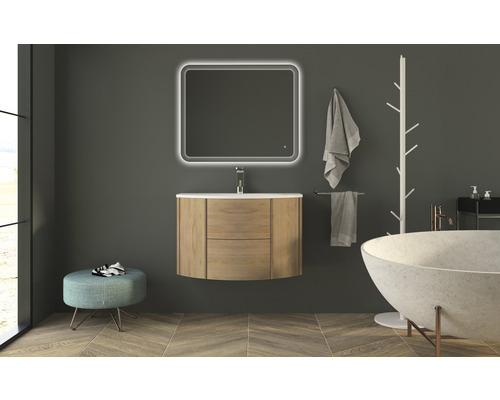 Badrum med tvättställsskåp, spegel med belysning, badkar och handdukar