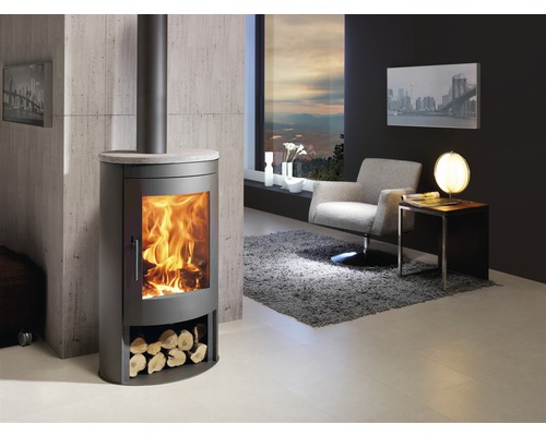 Vardagsrum med vedeldad kamin, fåtölj och sidobord