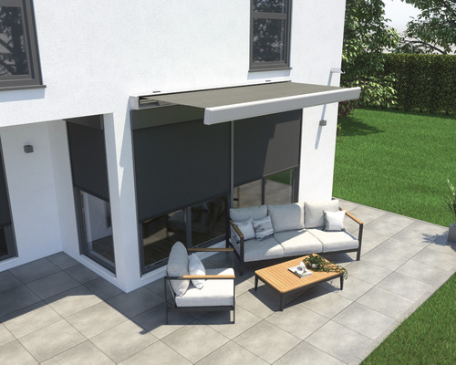 Terrass med markis, sittgrupp och stenläggning framför ett hus