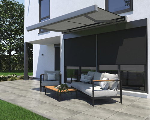 Terrass med markis och trädgårdsmöbler framför husfasad