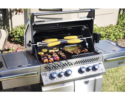 Grill i rostfritt stål med grillade produkter som majskolvar, spett och grönsaker