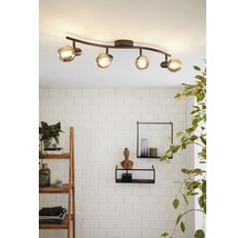 Taklampa med fyra spotlights och transparenta glaskulor i ett vardagsrum.