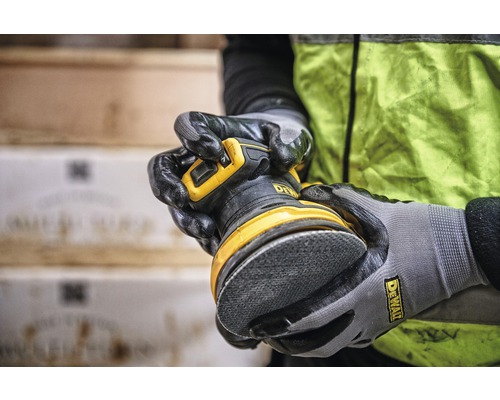 Person håller en excenterslipmaskin av märket DeWalt
