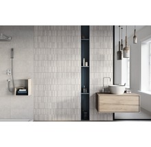 Ljust badrum med dusch, handfat och strukturerade väggplattor