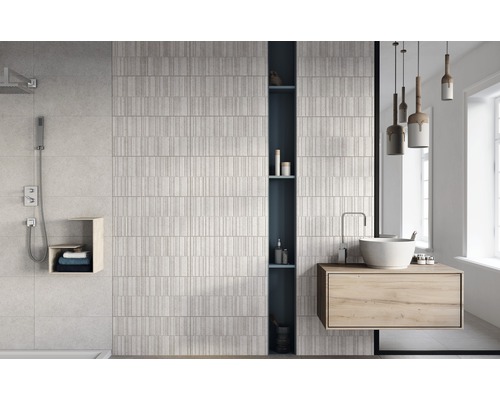 Ljust badrum med dusch, handfat och strukturerade väggplattor