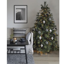 Dekorativt vardagsrum med julgran, soffa, bord och inramad bild