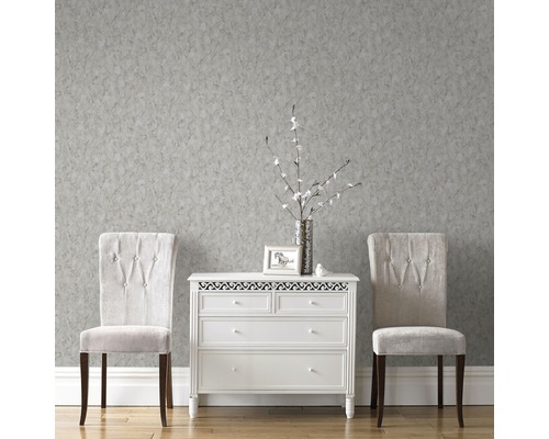 Rum med grå mönstrad tapet, byrå och två stolar