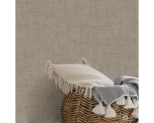 Dekorativ kudde och filt i en korg framför en strukturerad vägg