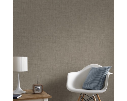 Närbild av en väggbeklädnad med textil struktur i ett vardagsrum.