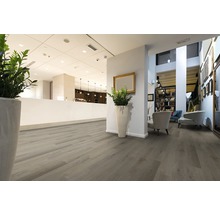 Interiör med ljust trägolv, sittgrupp och reception