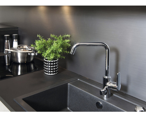 Köksscen med diskho, kran, kastrull, kryddkvarnar och krukväxt