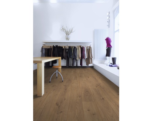 Ljust rum med laminatgolv, bord, stol och klädstång