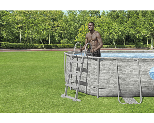 Ovanmarkspool med stege i trädgården