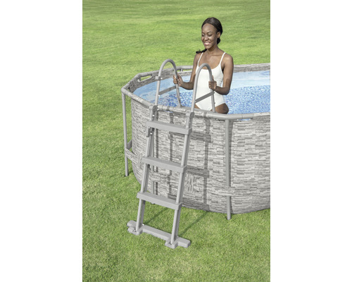 Ovanjordspool med stege och kvinna i vattnet