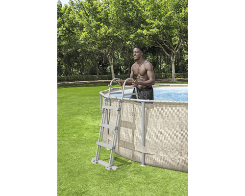 Ovanjordspool med stege och person i trädgården