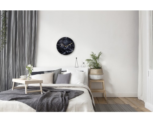 Sovrum med säng, dekoration och väggklocka med marmorlook