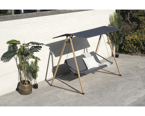 Trädgårdsgunga med soltak och kuddar på en terrass