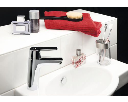 Tvättställsblandare i badrum med hygienprodukter och tillbehör