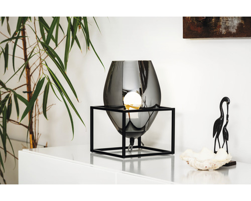 Dekorativ bordslampa med en ljuskälla i en svart metallram