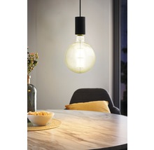 Dekorativ hänglampa med synlig glödlampa ovanför ett matbord